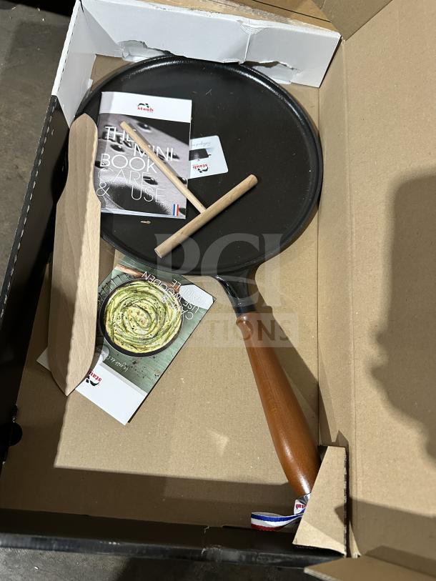 Brand new Staub CREPIERE 28 cm cast iron pancake pan with wooden handle, in box with manuals and accessories.