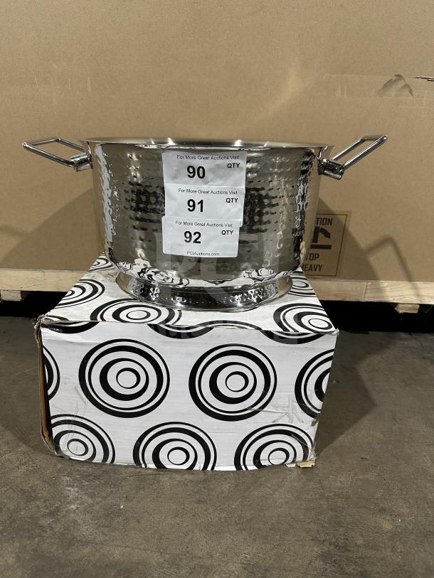 Brand new commercial stainless steel ice bucket with hammered finish and sturdy handles, displayed with original packaging.