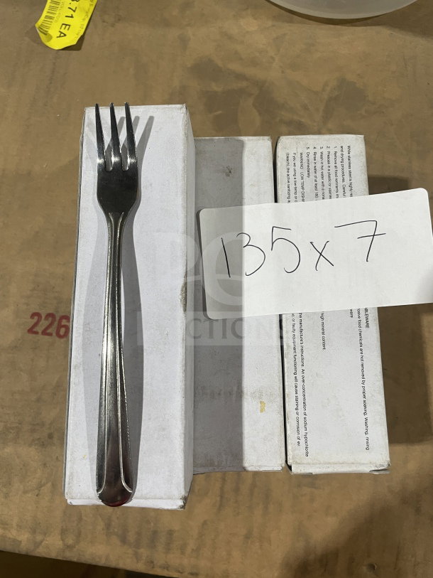 Brand new commercial stainless steel cocktail fork, set of seven, shown in packaging.