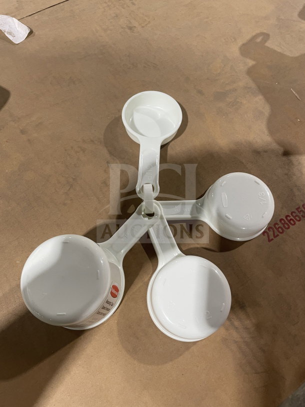 Brand new Winco commercial white measuring cup set, model L38315A0WHT. Includes four cups with measurement markings.