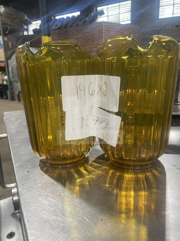 Brand new Rubbermaid gold beverage pitchers, model FG333800GOLD, with ribbed design. Auction labels attached.