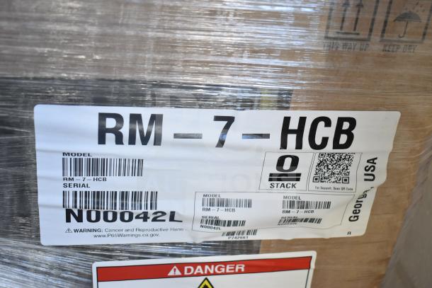Brand new 2023 Hoshizaki RM-7-HCB countertop refrigerator packaging with model label and warning signs visible.