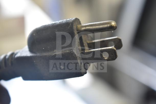 Close-up of a power plug for the Torrey TEC130L-UL Deli Display Case, showing metal prongs and part of a black power cord.