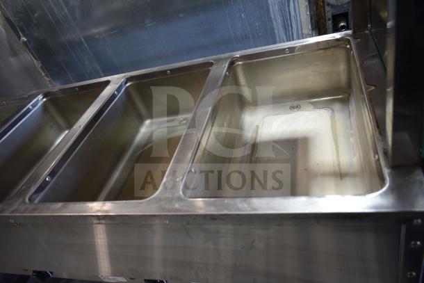 NH-4-240-SU commercial electric 4 well steam table, stainless steel, 240 volts. Visible wells and interior condition.