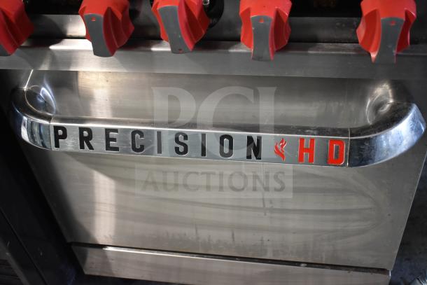 Precision commercial 4-burner range with oven, over shelf, backsplash, and casters. Branding: "PRECISION HD".