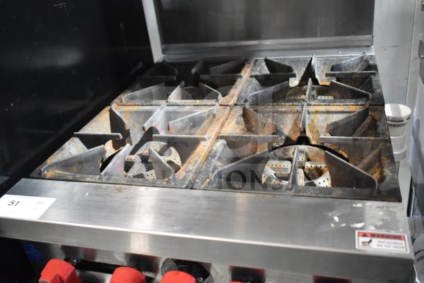 Precision commercial natural gas 4-burner range with oven, over shelf, and back splash on casters. Signs of rust and wear.