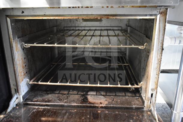 Precision 4 Burner Gas Range with Oven, Over Shelf, and Back Splash. Used condition, showing interior racks and commercial casters.