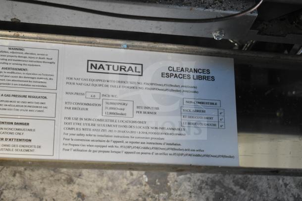 Precision natural gas 4-burner range with oven and over shelf. Features back splash, commercial casters. Seen labels indicate natural gas specifications and safety warnings.