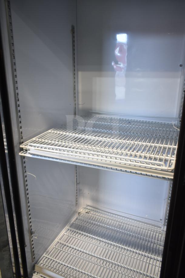 Dukers DSM-68SR Commercial 3 Door Cooler, interior view, wire shelving, clean condition, on commercial casters.