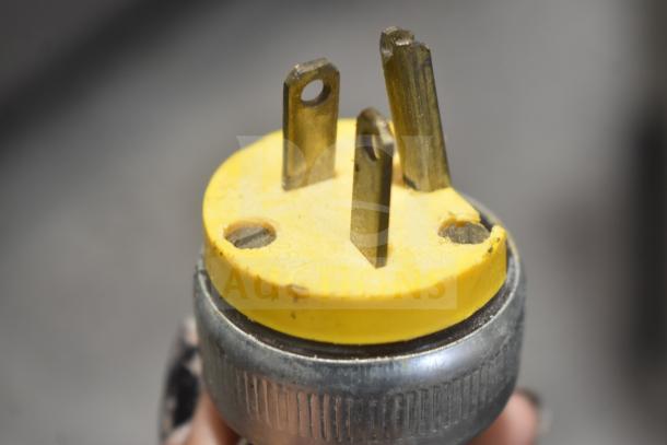 Close-up of a yellow and metal electrical plug for a Pasta Mat commercial pasta machine. 208 volts.