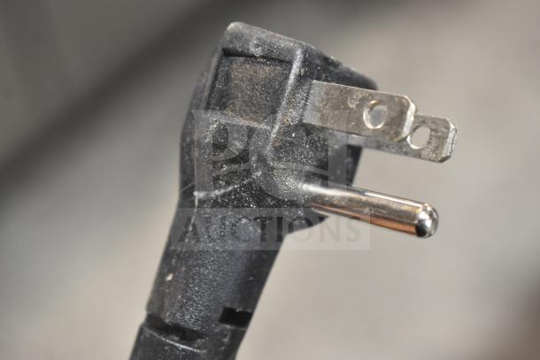 Close-up of a standard 115-volt plug from the Cowsar HZB-45A ice maker. Slight wear visible on the plug surface.