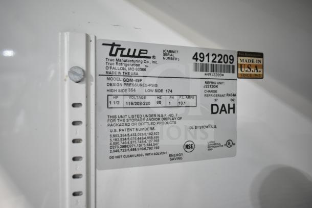 True GDM-49F commercial freezer label, revealing model, voltage (115/208-230), pressure specs, and refrigerant details.