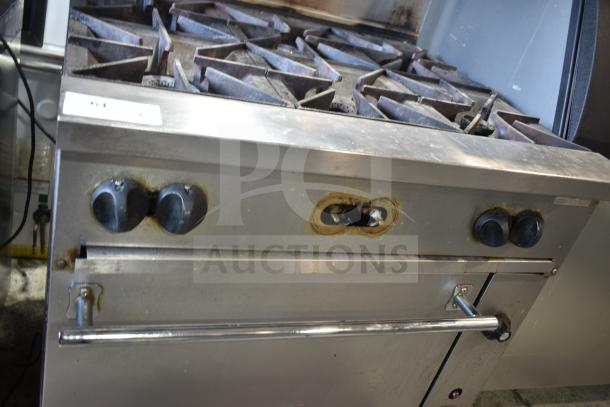 Vulcan 36S-6BN commercial gas range with 6 burners, oven, over shelf, backsplash, and commercial casters. Used condition.