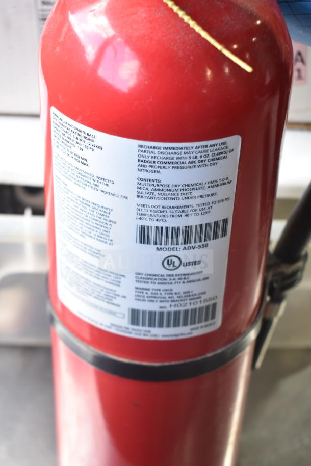 Red fire extinguisher with label showing model ADV-550, UL listed, suitable for temperatures -40F to 120F.