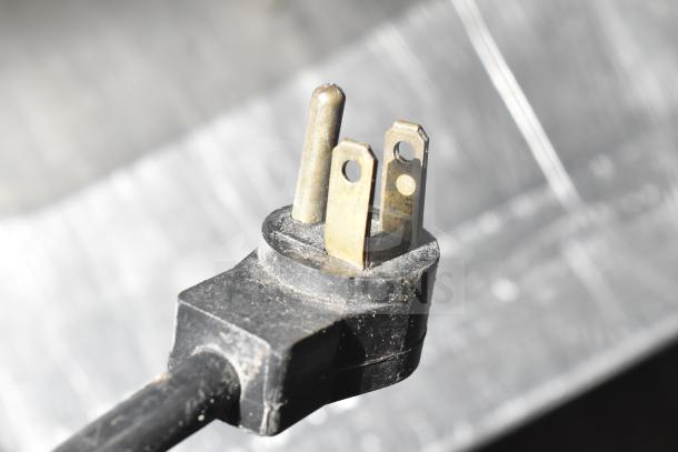 Close-up of a three-prong electrical plug for a Delfield 4448 undercounter cooler, 115 Volts, 1 Phase.