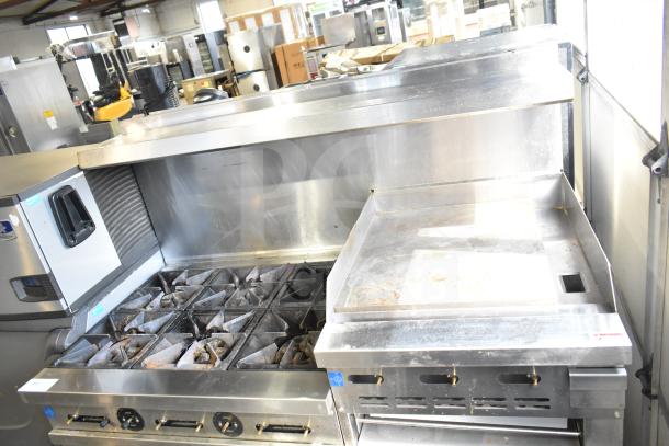 Precision RGR60-GS24-P commercial gas range with 6 burners, flat top griddle, 2 ovens, over shelf, and back splash on casters.
