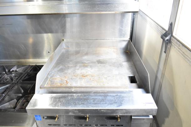 Precision RGR60-GS24-P commercial range with 6 burners, flat top griddle, 2 ovens, over shelf, and backsplash on casters.