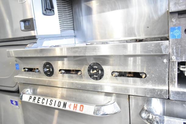 Commercial Precision RGR60-GS24-P gas range with 6 burners, flat top griddle, 2 ovens, over shelf, and backsplash.