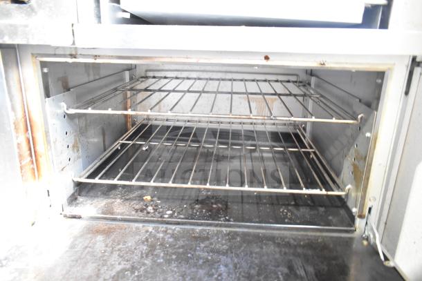 Precision RGR60-GS24-P commercial range oven interior with two racks, showing signs of use. Good condition.