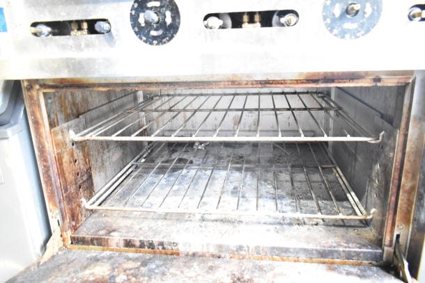 Precision RGR60-GS24-P commercial oven interior, showing wire racks; natural gas range in used condition.
