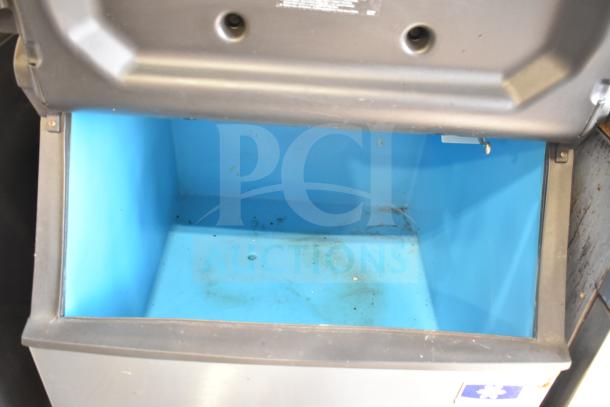 Manitowoc ID0303W-161D commercial ice maker on ice bin. 115 volts, 1 phase. Interior shows wear and debris.