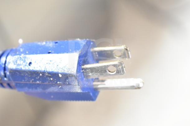 Close-up of a blue electric plug with visible wear and dust. Part of the Air King 9166G Fan and MainStays WSH07O2ABB Heater set.