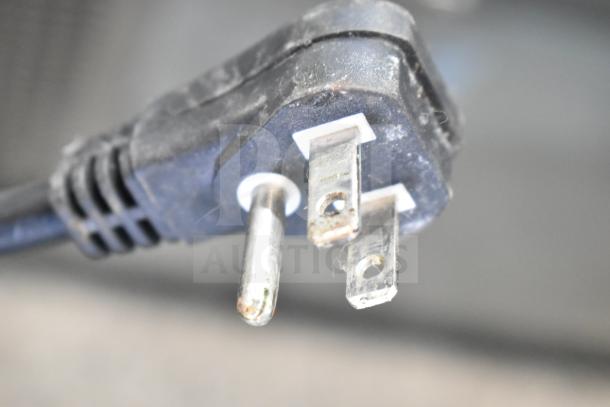Close-up of a black three-prong plug for the Turbo Air TCBE-36SDR-E-N6 Chef Base, showing wear and electrical contacts.