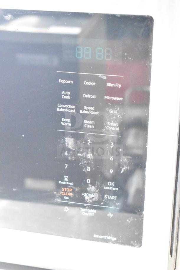 Samsung MC17T8000CS countertop microwave, featuring digital touch controls, visible usage wear. Model details on panel.