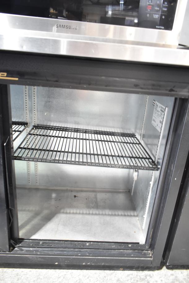 True TBB-24-60G-SD commercial back bar cooler with 2 glass doors, black exterior, metal shelves, 115 volts, 1 phase.