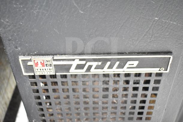 True TBB-24-60G-SD Back Bar Cooler with logo. 115 volts, 1 phase. Black exterior with ventilation grilles.