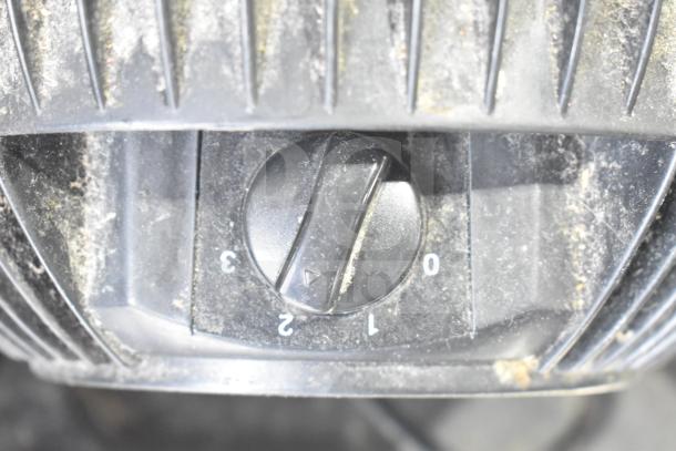 Close-up of a dusty control dial set to 0 on a black appliance, showing numbers 0-3 with visible wear.