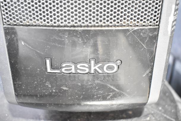Close-up of a Lasko appliance with visible logo, showing surface wear. Part of an auction set including fans and heaters.