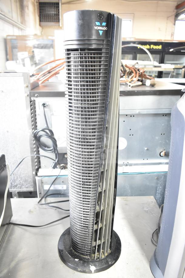Vornado 143 air circulating tower fan. Black with vertical grille. Visible dust indicates prior use. 120 volts, 1 phase.