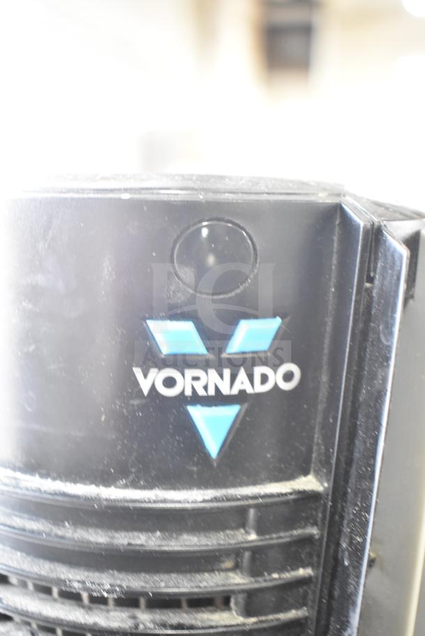 Vornado 143 air circulating tower fan, black with blue logo, part of a lot with various fans and heaters. Dust visible, 120 volts, 1 phase.