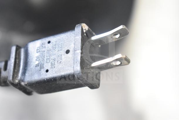Close-up of an electrical plug with "Use only with a fuse rated 2.5 amperes, 125 volts" text, for auction items including fans and heaters.