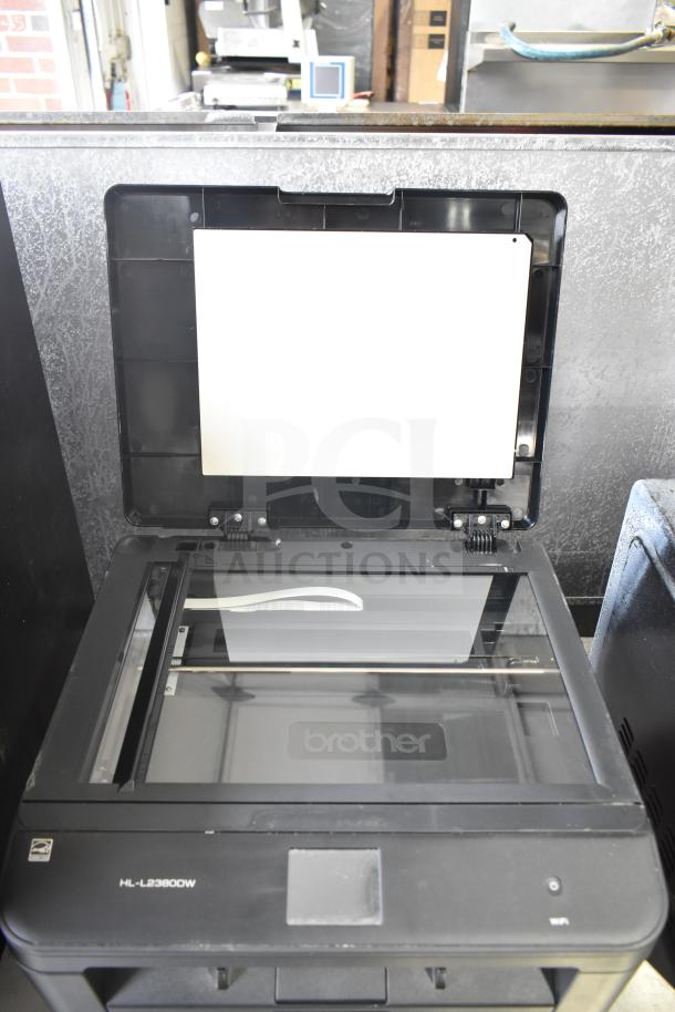 Brother HL-L2380DW printer-scanner with open lid showing glass scan surface, in good condition. Model label visible.
