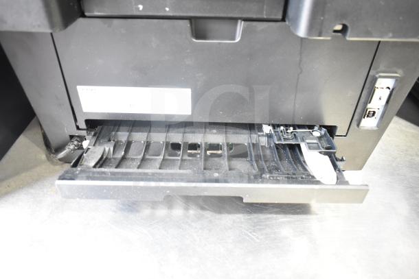 Brother HL-L2380DW printer/copier, showing paper tray open. Visible connections and minor dust present.