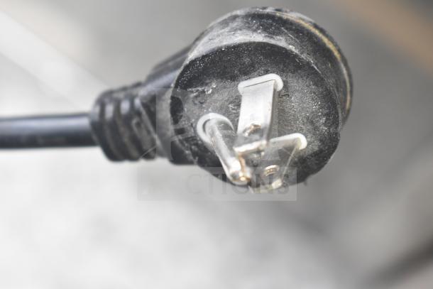 Close-up of a Summit SWC1102 power plug, showing a three-prong configuration. Plug condition appears slightly worn.