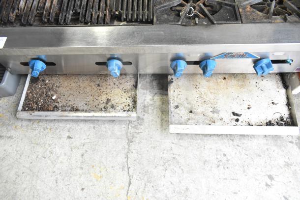 Prince Castle FHP48-2RB countertop natural gas charbroiler grill with 4 burners, visible wear, blue control knobs.