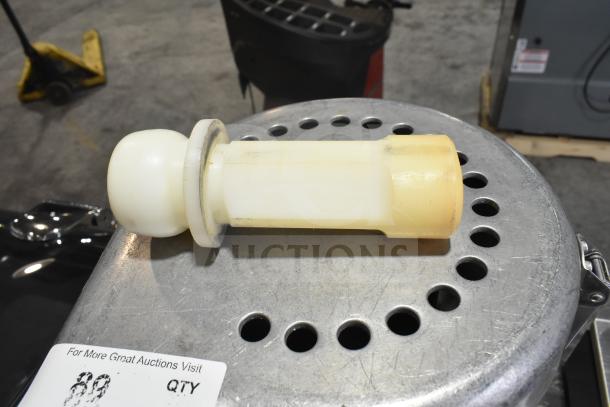 Commercial countertop citrus juicer part from The Ruby 2000, shown on a perforated metal surface, includes auction label.