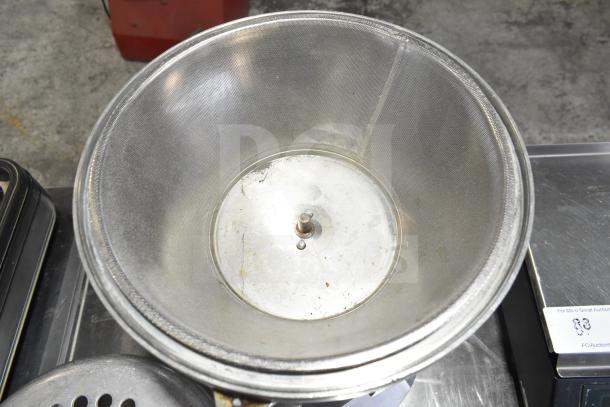 The Ruby 2000 Commercial Citrus Juicer, stainless steel, 115-117 volts, 1 phase, used condition, visible mechanics.