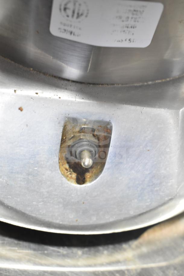 The Ruby 2000 Commercial Countertop Citrus Juicer, 115-117V, metal surface with visible wear, label partially visible.