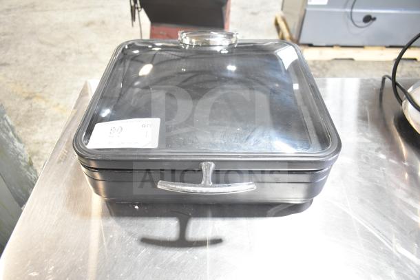 Square black container with transparent lid and chrome handle, labeled "Spring Bin." Appears in used condition.