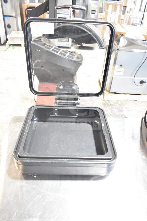 Black Spring Bin with clear hinged lid, in good condition. Features durable construction and spacious interior. Visible tag on lid.
