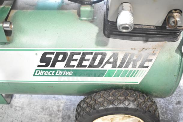 Speedaire 5Z032A Direct Drive Air Compressor, featuring green metal body, visible label, and sturdy wheels.