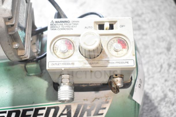 Speedaire 5Z032A Direct Drive Air Compressor, showing pressure gauges, regulator, and warning label for tank moisture drainage.
