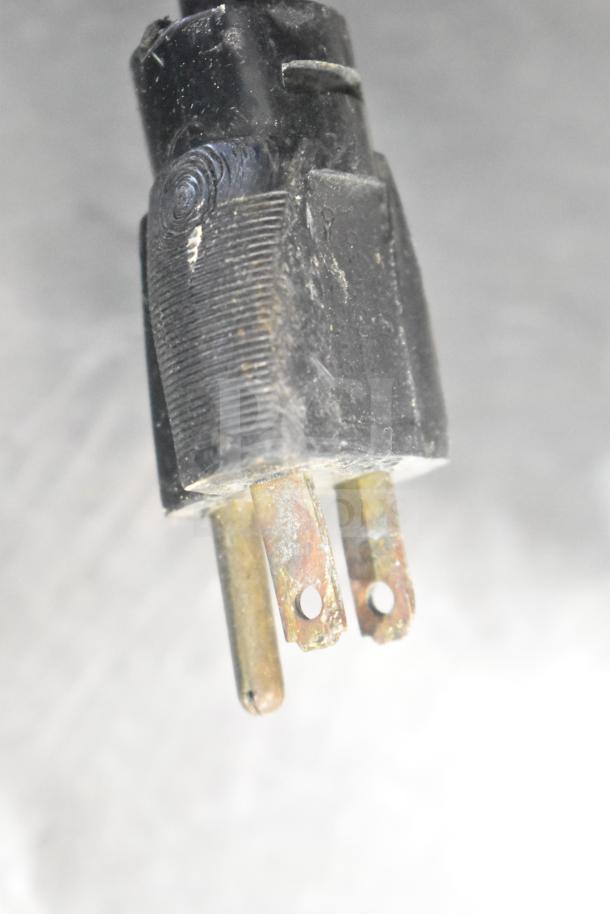 Close-up of a worn plug for a Speedaire 5Z032A Direct Drive Air Compressor, showing signs of use and slight corrosion.