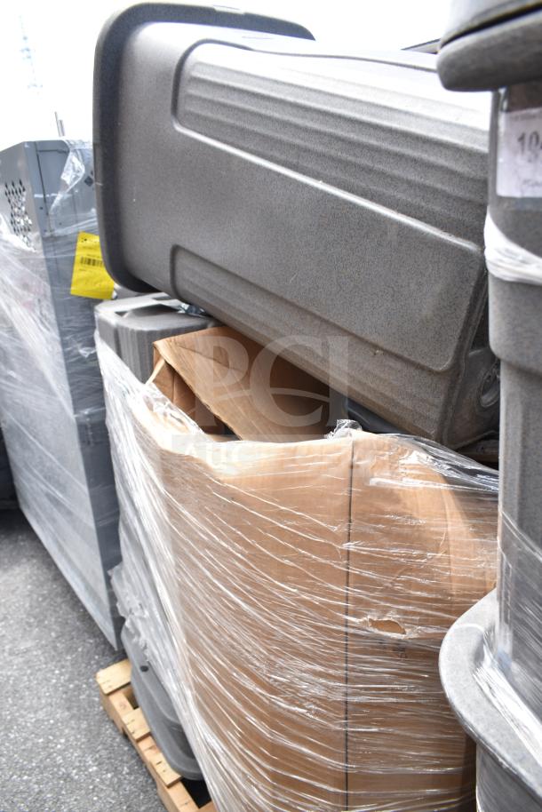 Eight assorted trash cans stacked and wrapped in plastic on a pallet, showing durable gray material and secure packaging.
