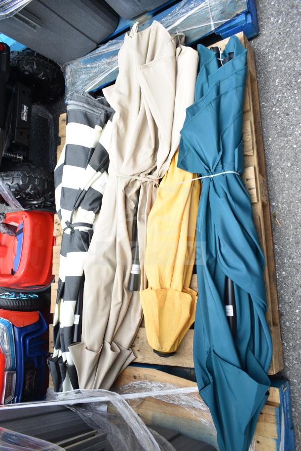 Five assorted items: four patio umbrellas in various colors and one wet chemical fire extinguisher on a pallet.