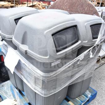 Four gray commercial trash cans with dome lids, stacked on a blue pallet, wrapped in plastic, showing minor wear.